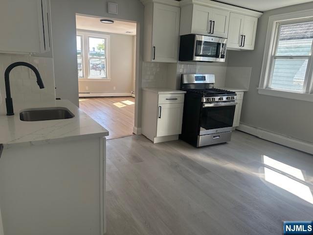6 Pleasant Avenue, Unit 2 Clifton, NJ 07013 - Photo 4 of 14 a kitchen with stainless steel appliances granite countertop a stove a sink dishwasher and a microwave