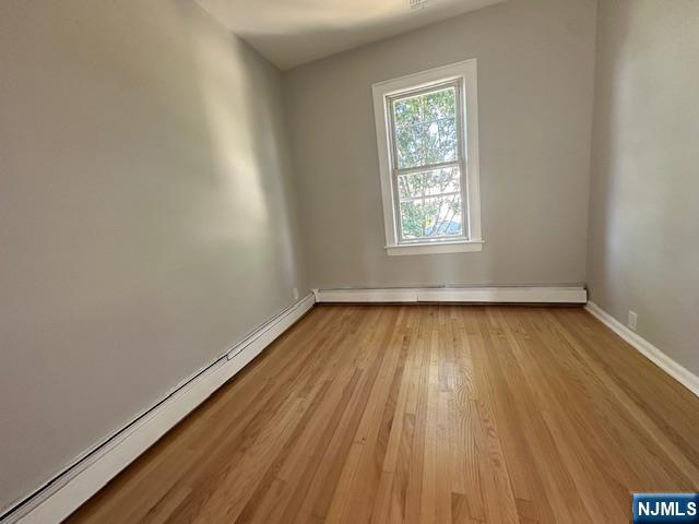 6 Pleasant Avenue, Unit 2 Clifton, NJ 07013 - Photo 10 of 14 an empty room with wooden floor and windows