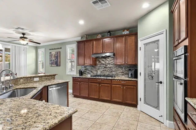 a kitchen with stainless steel appliances granite countertop a refrigerator and a stove