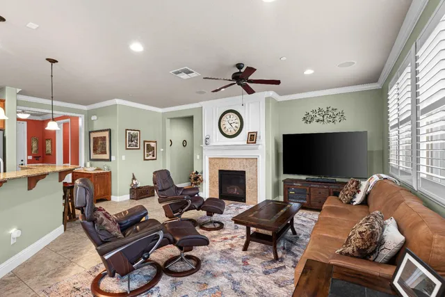 a living room with furniture a fireplace and a large window