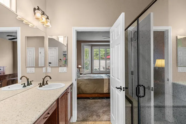 a view of a backyard with table and chairs under an umbrella with a fire pit and plants