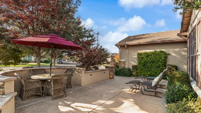 a patio with a table and chairs under an umbrella