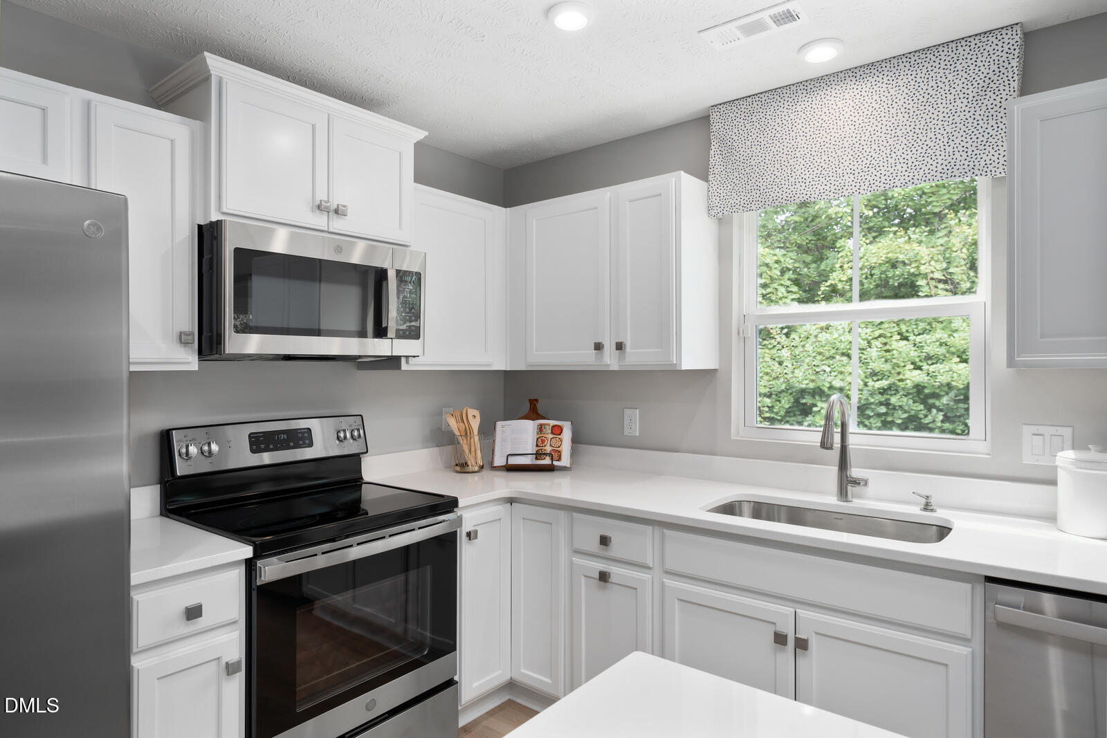 264 Matthiola Drive Wendell, NC 27591 - Photo 2 of 33 a kitchen with stainless steel appliances a sink a stove a microwave and cabinets