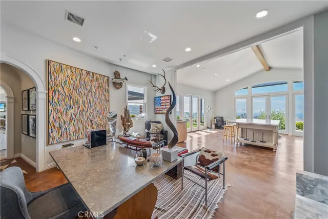 a kitchen with stainless steel appliances kitchen island granite countertop a stove and white cabinets