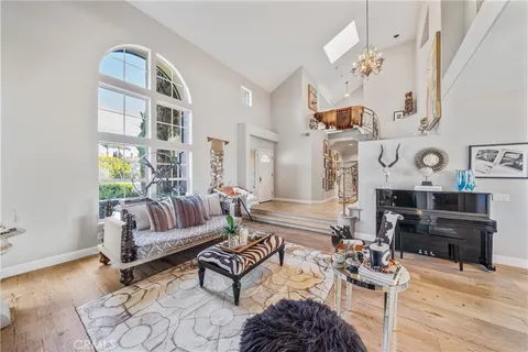 a view of a dining room with furniture a chandelier and a window
