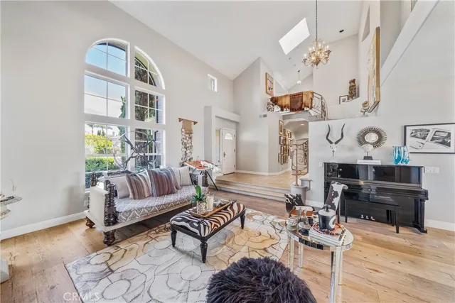 a view of a dining room with furniture a chandelier and a window
