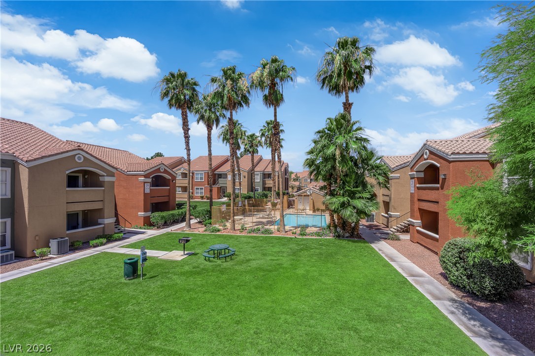 8101 West Flamingo Road, Unit 2152 Las Vegas, NV 89147 - Photo 25 of 45 Palm-lined green space leads to a sparkling community pool, a perfect oasis.