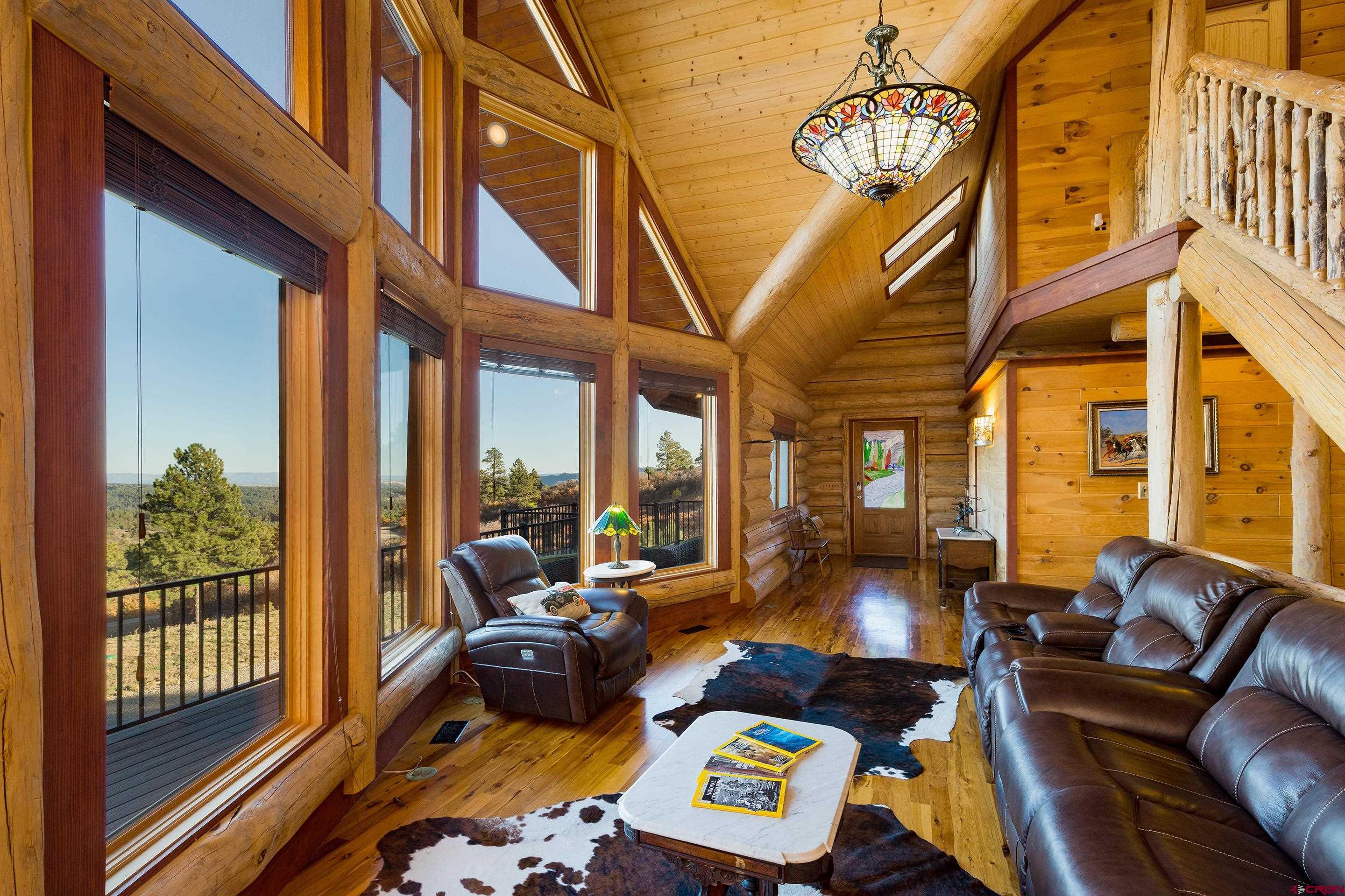205 West Durango Ridge Road Durango, CO 81301 - Photo 5 of 35 a living room with furniture three large windows and wooden floor