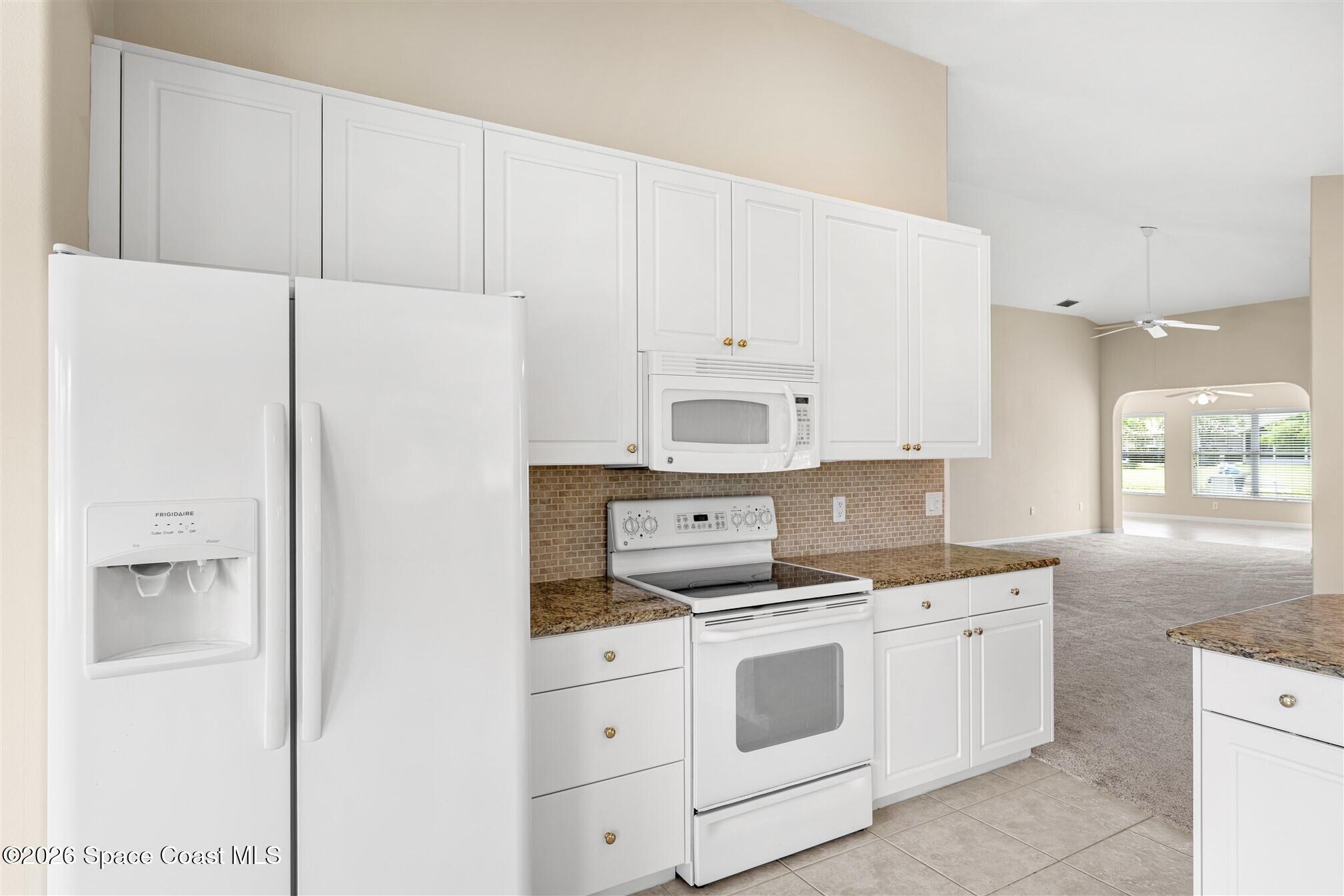 6904 Renshaw Drive Melbourne, FL 32940 - Photo 9 of 46 a kitchen with cabinets appliances and a counter space