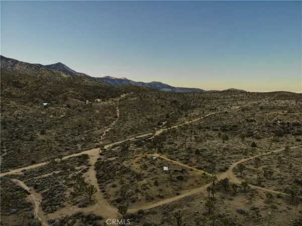 a view of a dry yard with mountains in the background