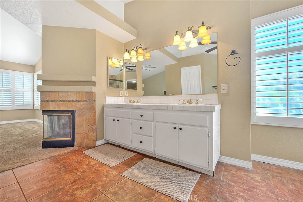 28832 Harwick Drive Highland, CA 92346 - Photo 42 of 62 a spacious bathroom with a granite countertop sink a mirror and a vanity