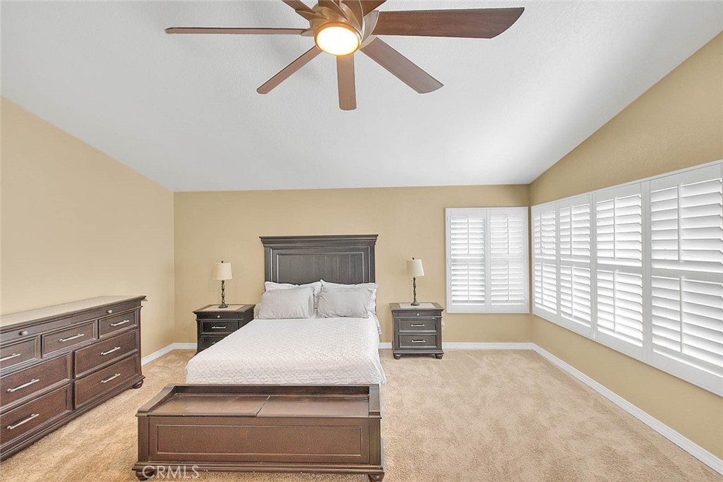 28832 Harwick Drive Highland, CA 92346 - Photo 54 of 62 a spacious bedroom with a large bed and a chandelier fan