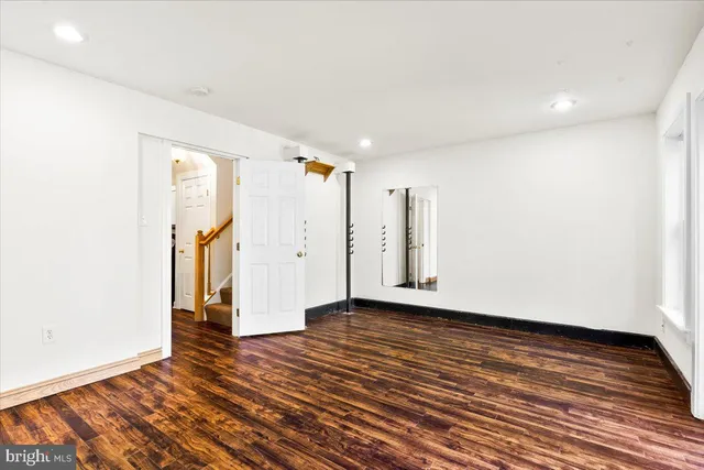 a view of an empty room with wooden floor and closet