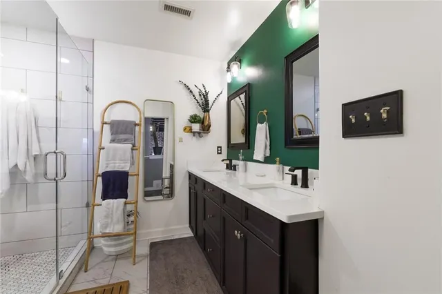 a spacious bathroom with a double vanity sink and mirror