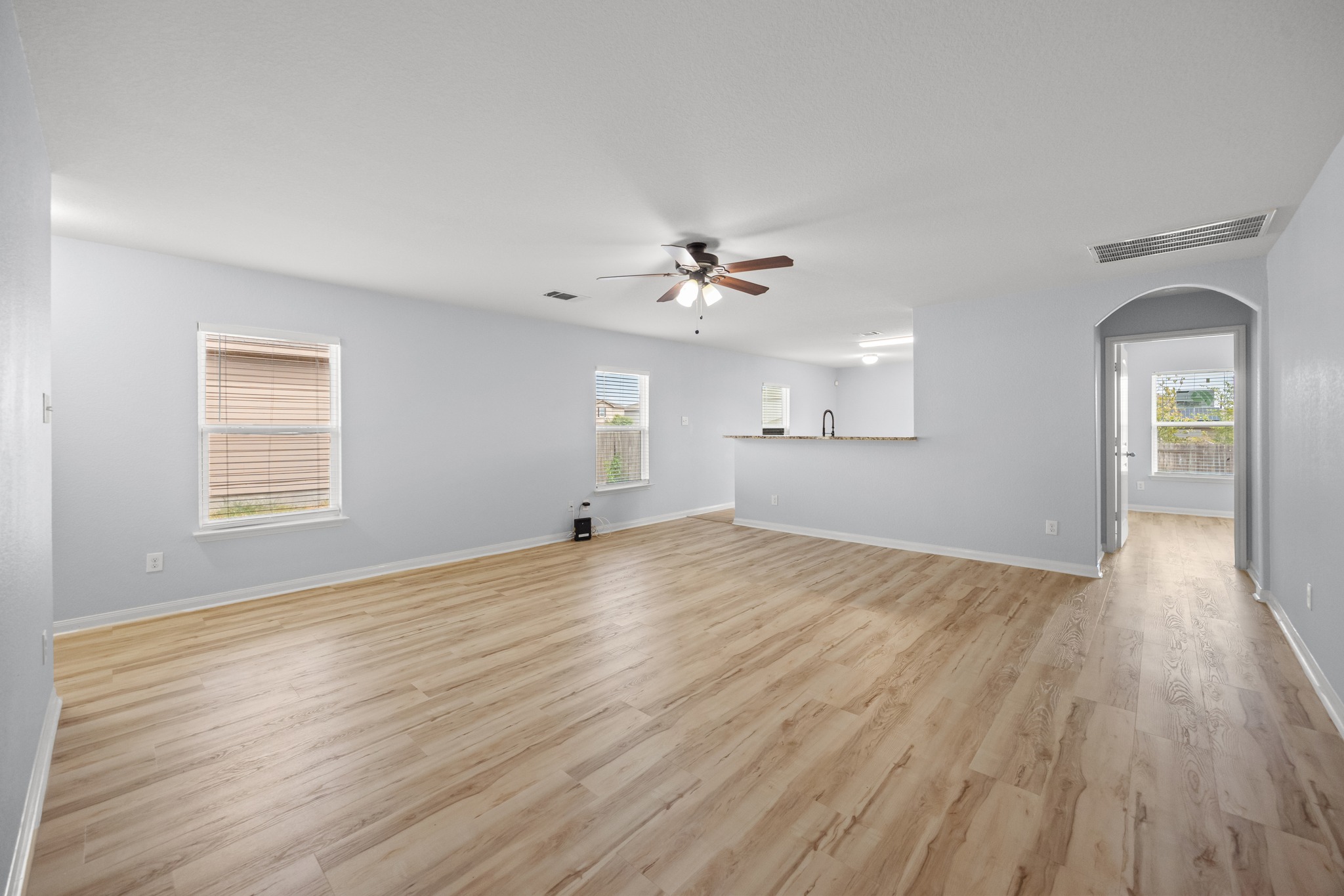 228 Millers Loop Jarrell, TX 76537 - Photo 8 of 26 Gleaming wood-look floors anchor a generous living space connected seamlessly to the kitchen.