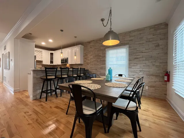 a dining room with a table chairs and a kitchen view