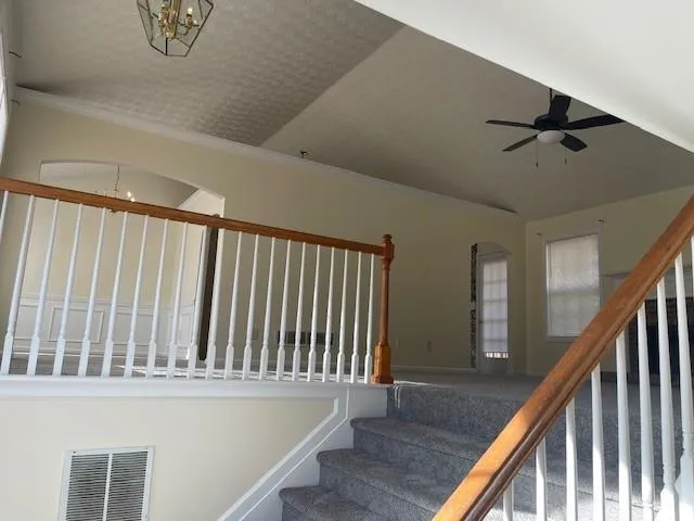 a view of staircase with railing and white walls