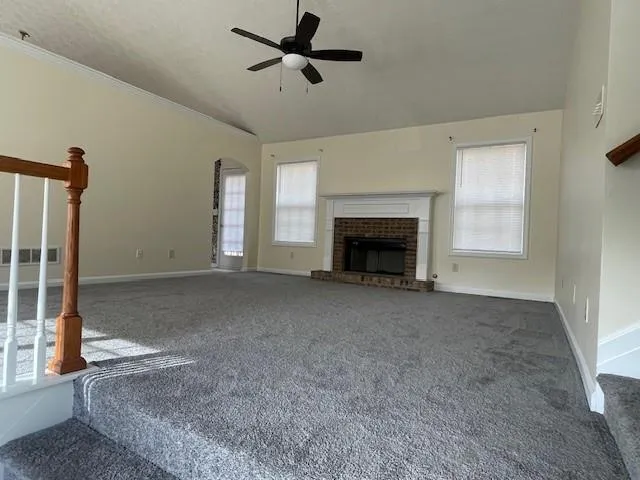 a view of an empty room with a fireplace and a window