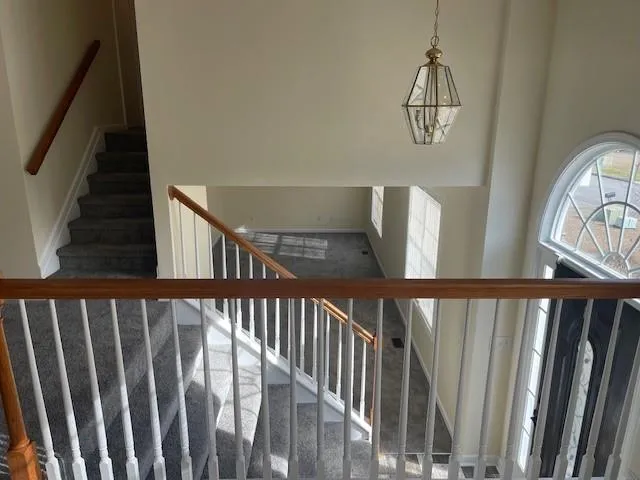 a view of staircase with railing and white walls