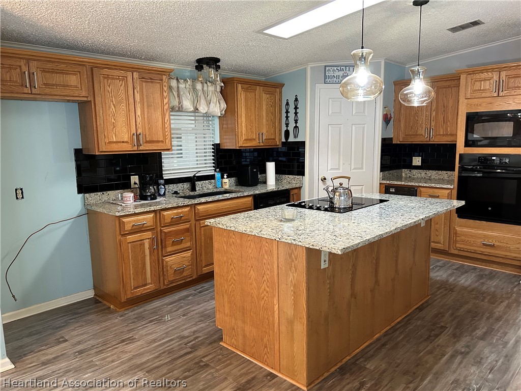 337 Hickory Ridge Drive Sebring, FL 33876 - Photo 44 of 48 a kitchen with stainless steel appliances granite countertop a sink a stove and a wooden floor
