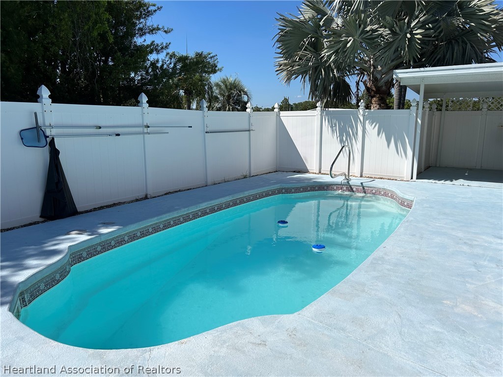 337 Hickory Ridge Drive Sebring, FL 33876 - Photo 10 of 48 a view of a swimming pool with a chairs in the patio