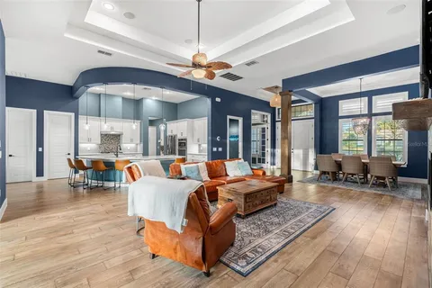 a kitchen with stainless steel appliances kitchen island granite countertop a table chairs in it and wooden floors