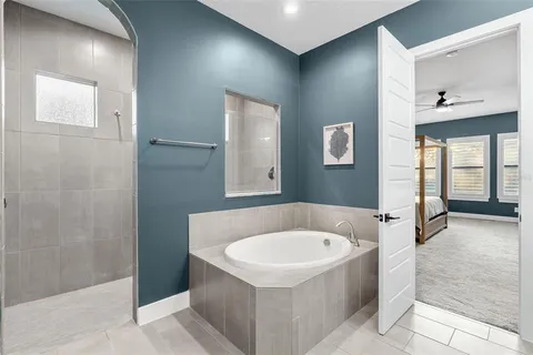 a view of an empty room with a window and a ceiling fan