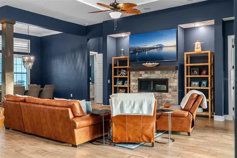 a living room with furniture a chandelier and a large window