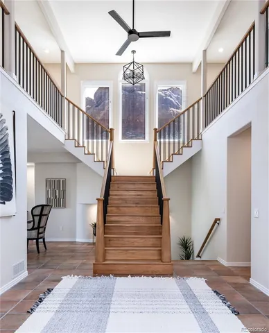 a view of staircase with lots of frames on wall and a chandelier