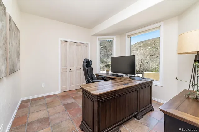a living room with furniture potted plant and a large window