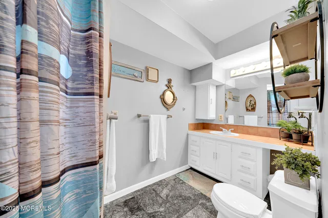 a bathroom with a granite countertop sink mirror vanity and toilet