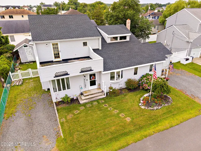 an aerial view of a house with swimming pool and large trees