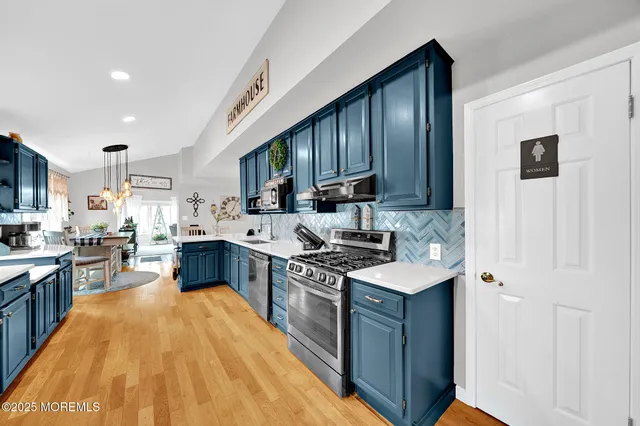 a kitchen with stainless steel appliances granite countertop wooden cabinets sink stove and refrigerator