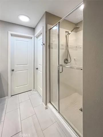 a bathroom with a glass shower door and mirror