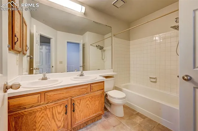 a bathroom with a granite countertop sink a toilet a mirror a vanity a bathtub and shower