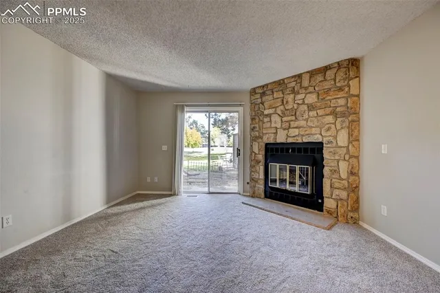 a view of an empty room with a fireplace and a window
