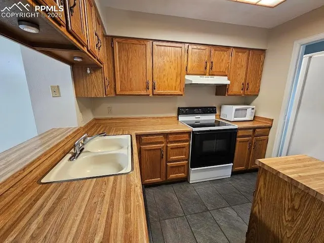 a kitchen with a stove sink and cabinets