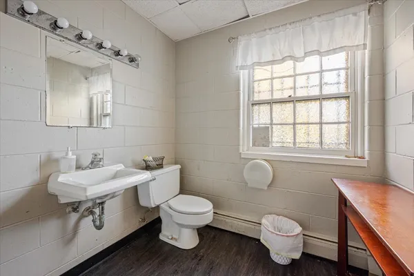 a bathroom with a white toilet sink and mirror