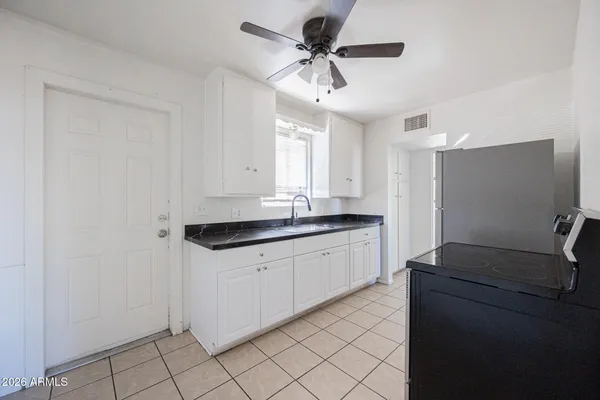 a kitchen with granite countertop white cabinets and white appliances