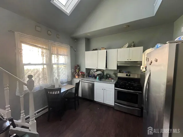 a kitchen with granite countertop a refrigerator stove and sink