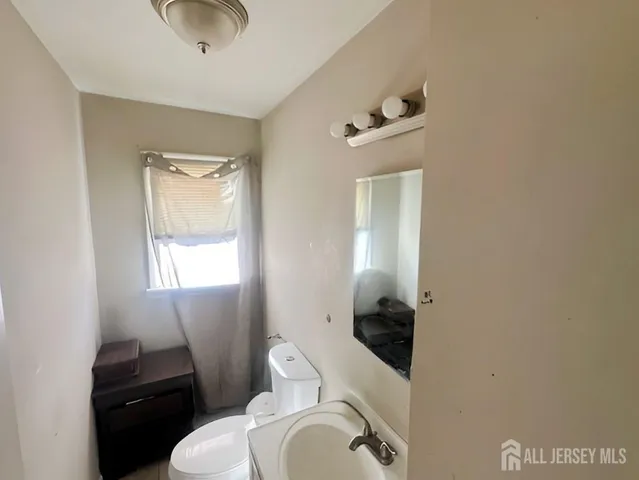 a bathroom with a toilet a sink and mirror