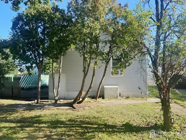 a backyard of a house with table and chairs