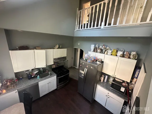 a kitchen with stainless steel appliances granite countertop a refrigerator and a stove top oven