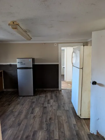 a view of empty room with a fireplace and wooden floor