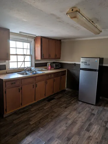 a kitchen with a sink cabinets and wooden floor