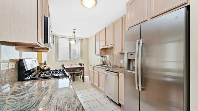 a kitchen with a refrigerator a stove a sink and white cabinets with wooden floor