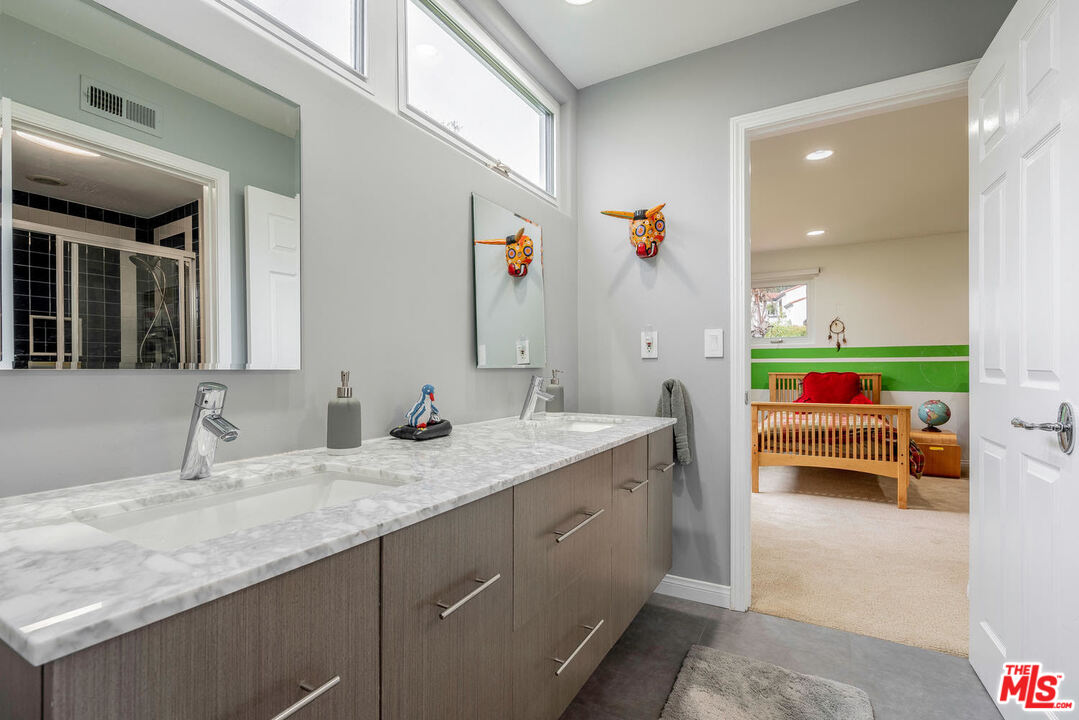 24050 Park Casino Calabasas, CA 91302 - Photo 36 of 43 a en suite bathroom with a granite countertop sink and a mirror