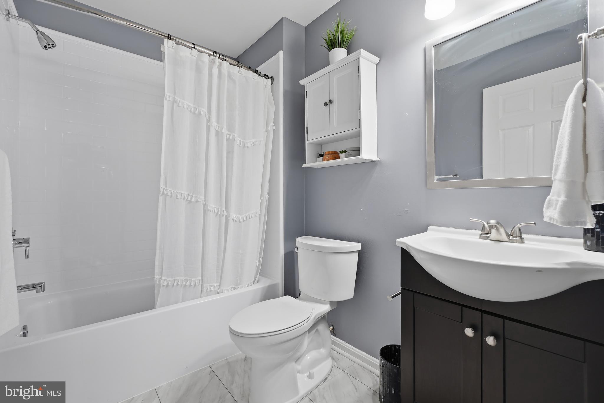 14151 Cuddy Loop, Unit 101 Woodbridge, VA 22193 - Photo 17 of 45 a bathroom with a sink a toilet and shower curtain
