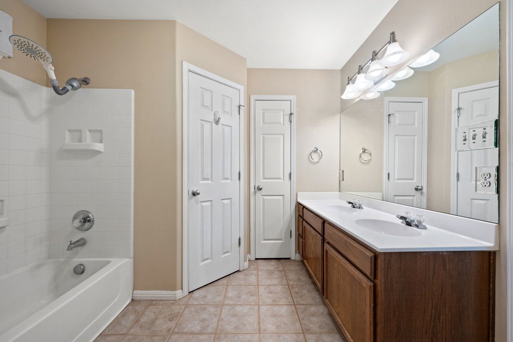 5208 Sioux Lane Austin, TX 78734 - Photo 25 of 35 Dual vanities and a full-size tub with shower enclosure offer convenience in this functional bathroom.