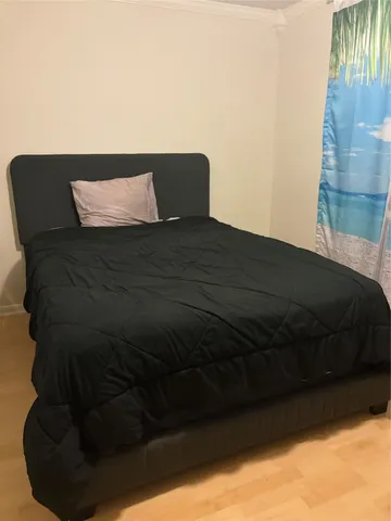 a bed sitting in a bedroom next to a window